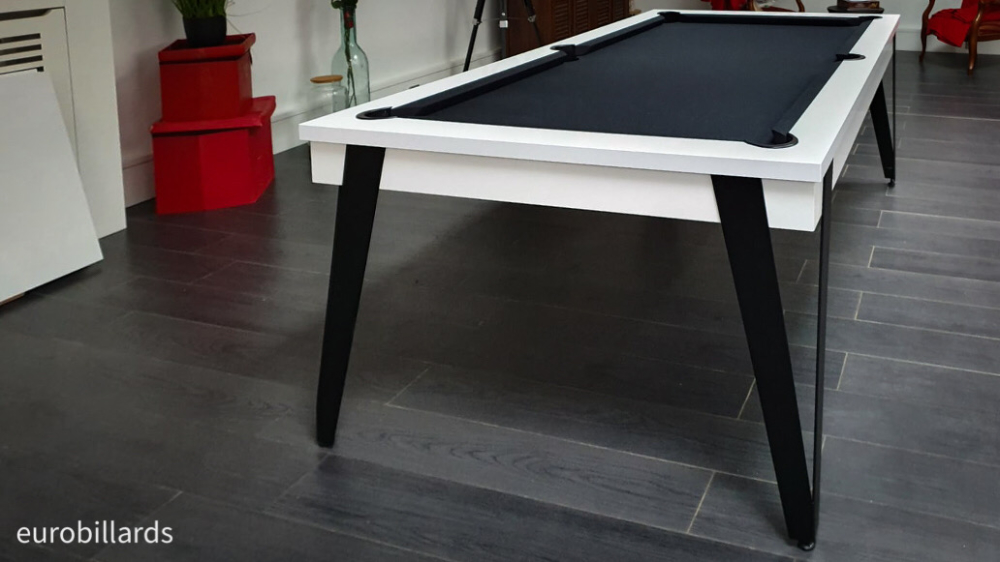 Les éléments de plateau table ST déposés sur le côté font place à l'élégant jeu de billard américain au tissu de jeu noir, qui prolonge les fines lignes de métal dessiné par les pieds d'inspiration indutrielle mis en valeur par le contraste avec le blanc nano mat de la finition du cadre de billard. Un superbe ajustement de design contemporain avec l'héritage des métiers d'art